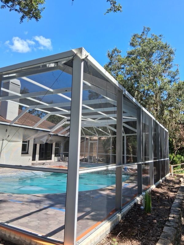 Sun-faded white pool cage before refinishing